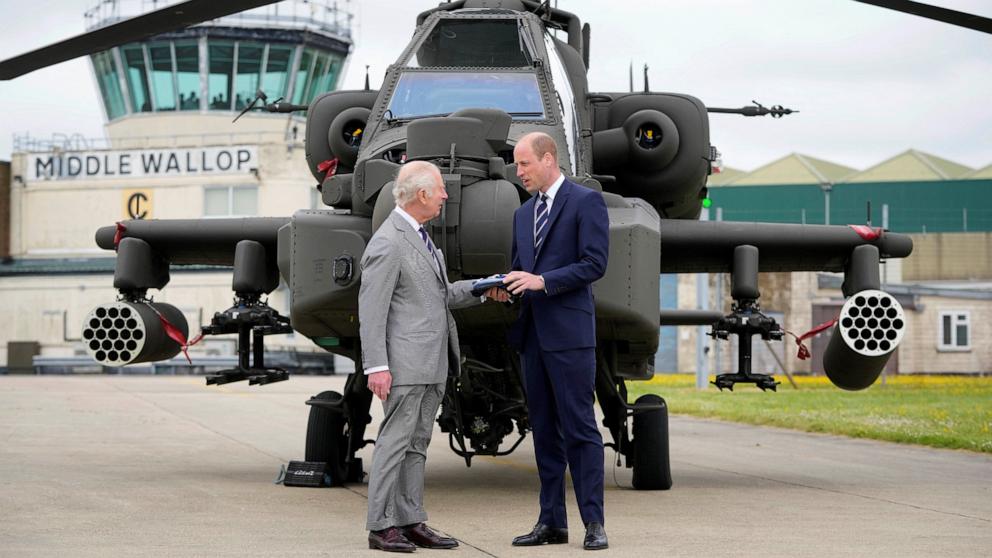 PHOTO: Britain's King Charles III officially hands over the role of Colonel-in-Chief of the Army Air Corps to Britain's Prince William in front of an Apache helicopter in Middle Wallop, England, on May 13, 2024. 