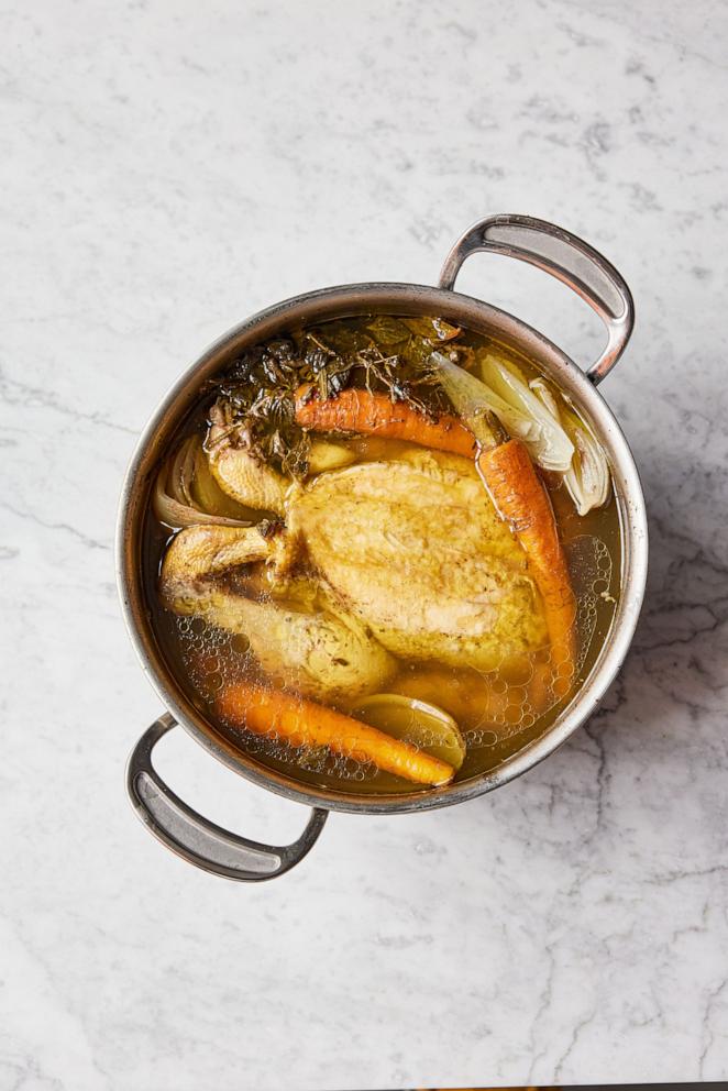 PHOTO: A pot of homemade poached chicken with carrots and aromatics. 