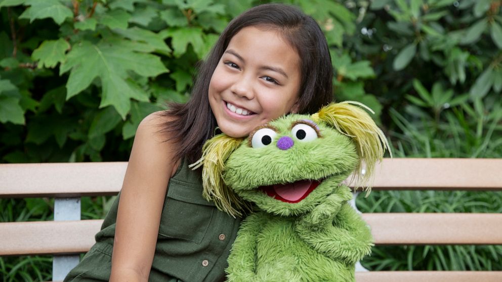 PHOTO: Salia Woodbury, whose parents are in recovery sits with "Sesame Street" character Karli.