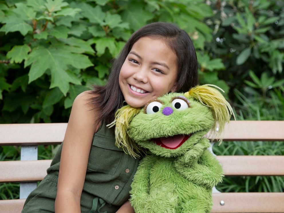 PHOTO: Salia Woodbury, whose parents are in recovery sits with Sesame Street character Karli.