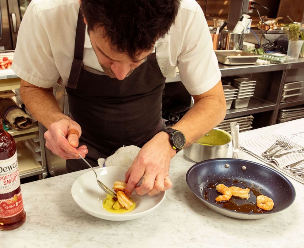 PHOTO: Chef George Mendes plates his seared shrimp with Portuguese Goan curry broth that he paired with a Dewar's Portuguese Smooth old-fashioned cocktail.