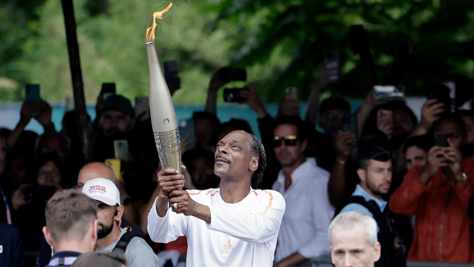 PHOTO: Snoop Dogg holds the torch as part of the 2024 Paris Olympic Games Torch Relay, in Saint-Denis, July 26, 2024.