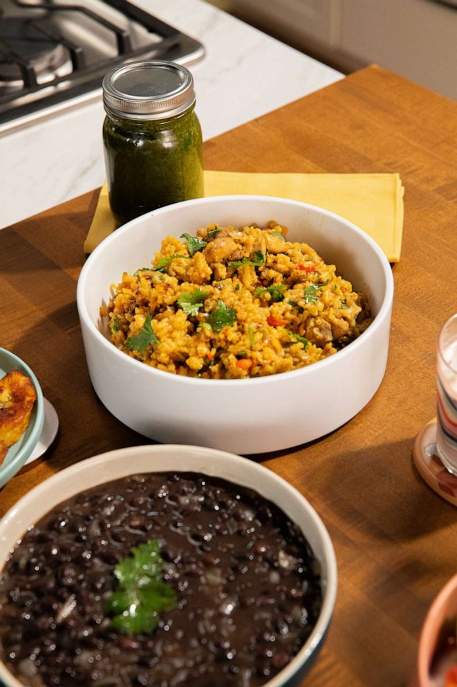 PHOTO: A bowl of arroz con pollo with a side of black beans.