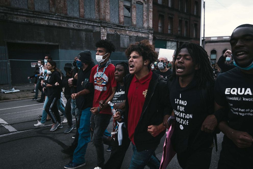 PHOTO: Stefan Perez locks arms with other protesters while marching down a Detroit street.