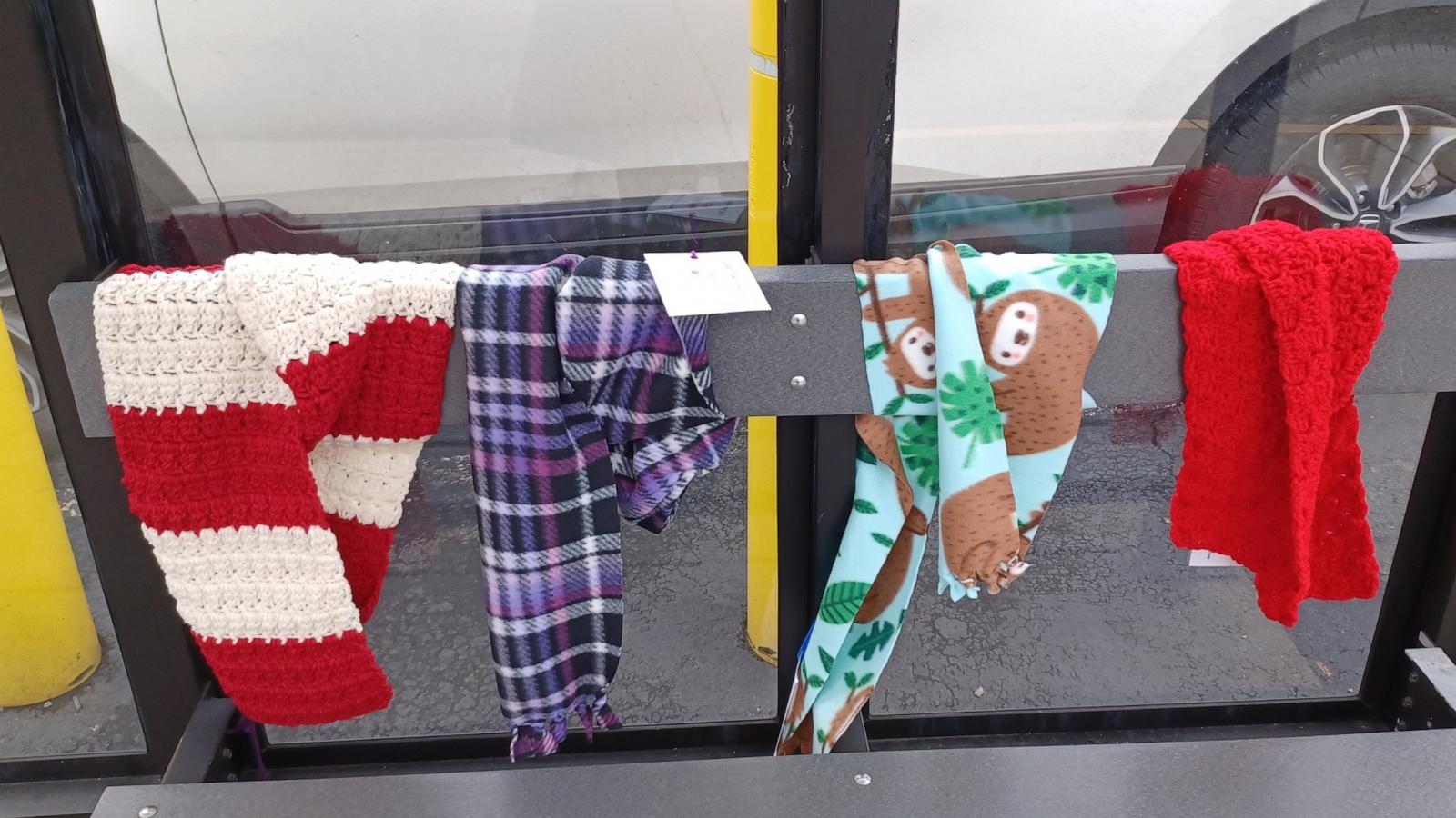 PHOTO: During the winter months, Suzanne Volpe and members of the Scarf Bombardiers “bombard” bus shelters and railings outside of public buildings like churches with handmade scarves for anyone to take and use.