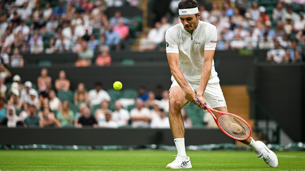 Taylor Fritz returns a shot from unranked French tennis player Giovanni Mpetshi Perricard during the Men's Singles First Round match on day one of The Championships Wimbledon 2025.