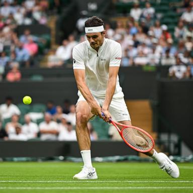 Taylor Fritz returns a shot from unranked French tennis player Giovanni Mpetshi Perricard during the Men's Singles First Round match on day one of The Championships Wimbledon 2025.