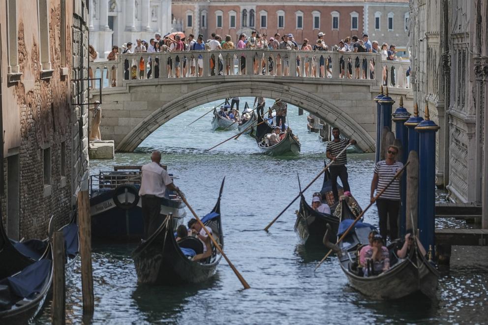 PHOTO: Gondoliers proceed slowly near the Sospiri Bridge near St. Mark's Square due to too much traffic in Venice, Italy, Aug. 02, 2023. 