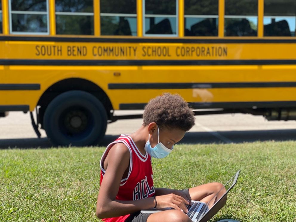 PHOTO: Tre'Vonne Wallace, an eighth grader at Navarre Middle School in South Bend, Ind., sits with a computer outside one of South Bend Community School Corporation's Wi-Fi buses. 