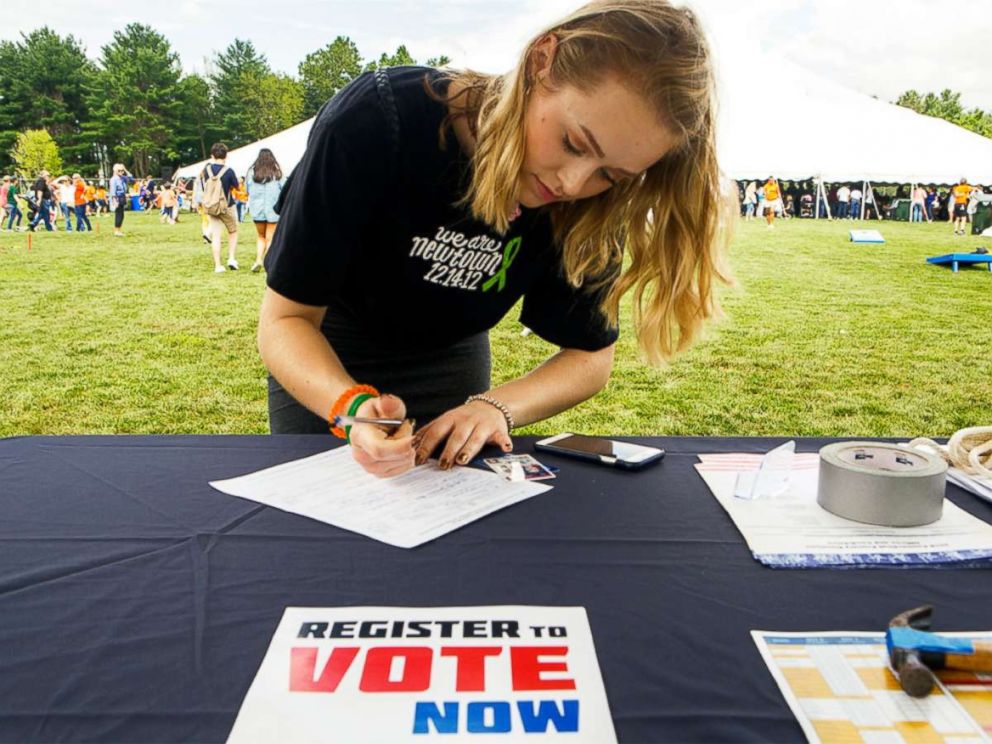 PHOTO: A young woman registers to vote.	