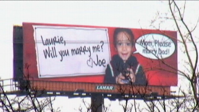VIDEO: New York man wins girlfriends heart with a billboard featuring her son.
