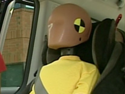 A picture if a crash test dummy in a booster seat.