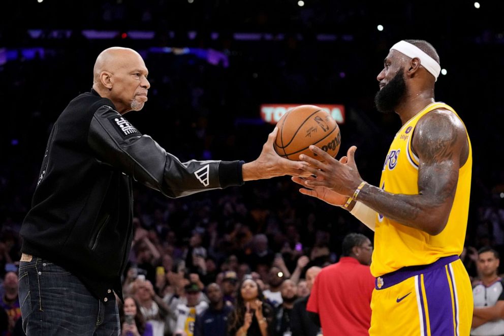 PHOTO: Kareem Abdul-Jabbar, left, hands the ball to Los Angeles Lakers' LeBron James after he passed Abdul-Jabbar to become the NBA's all-time leading scorer during the second half of a game against the Oklahoma City Thunder, Feb. 7, 2023, in Los Angeles.