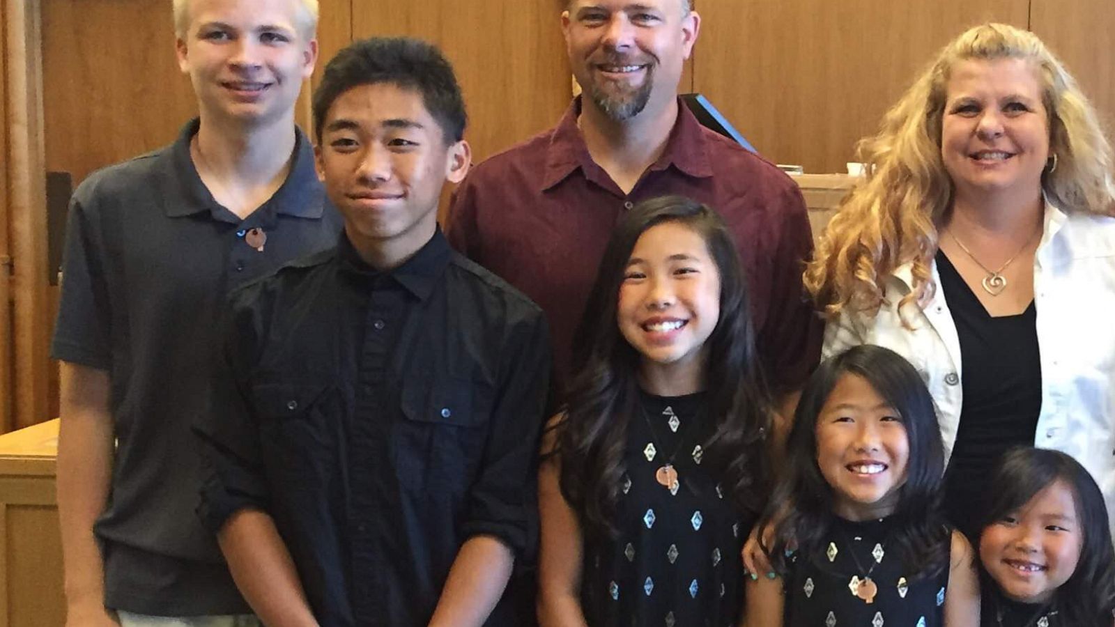 PHOTO: All eight members of the Brostowitz family stand in a courtroom on their adoption day in 2017.