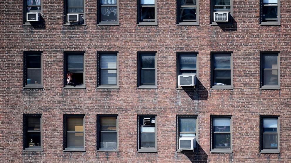 PHOTO: In this March 24, 2020, file photo, a person looks out of their window in New York.