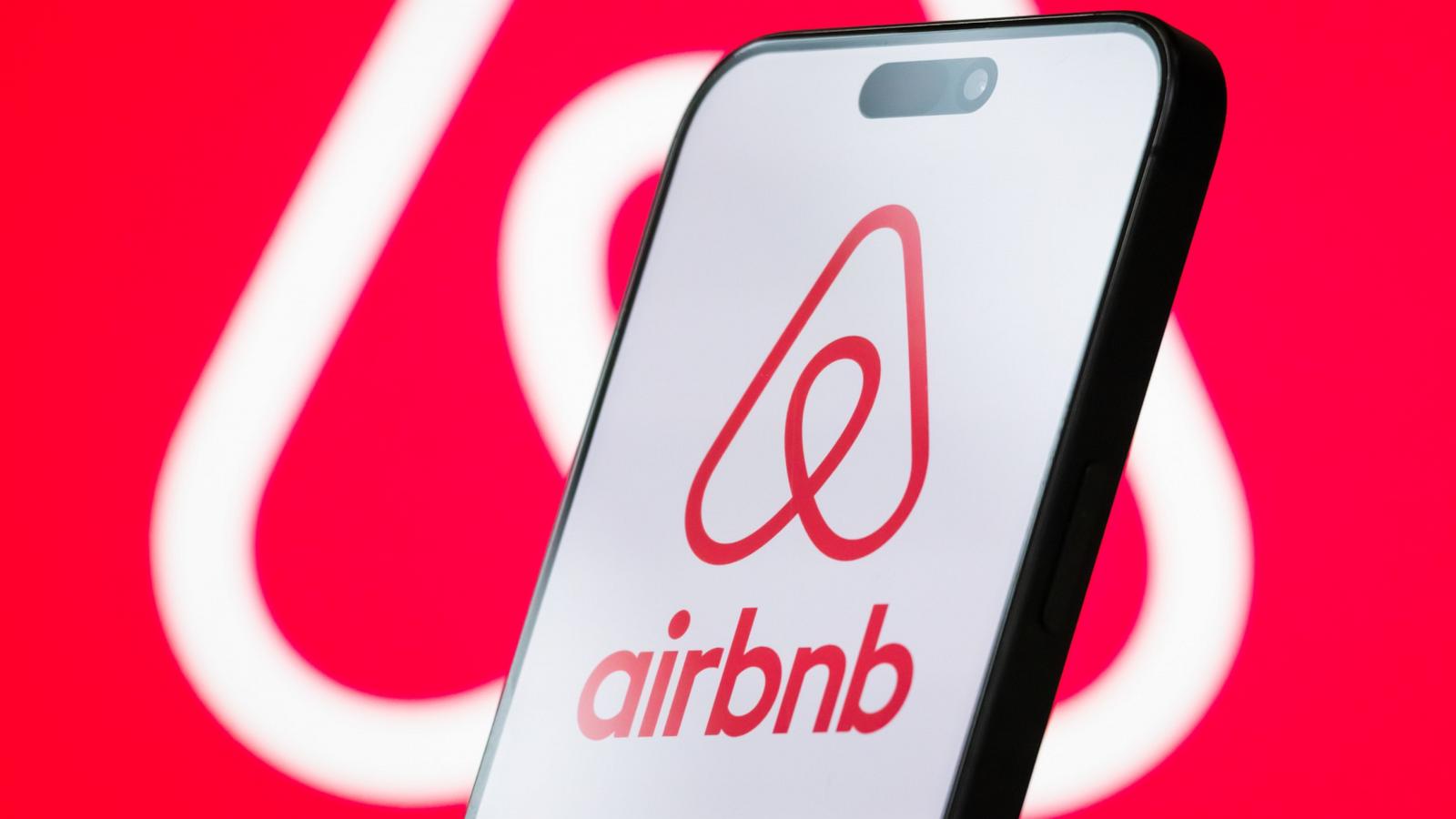 PHOTO: The logo of Airbnb, Inc. is displayed on a smartphone screen, with the company's branding visible in the background.