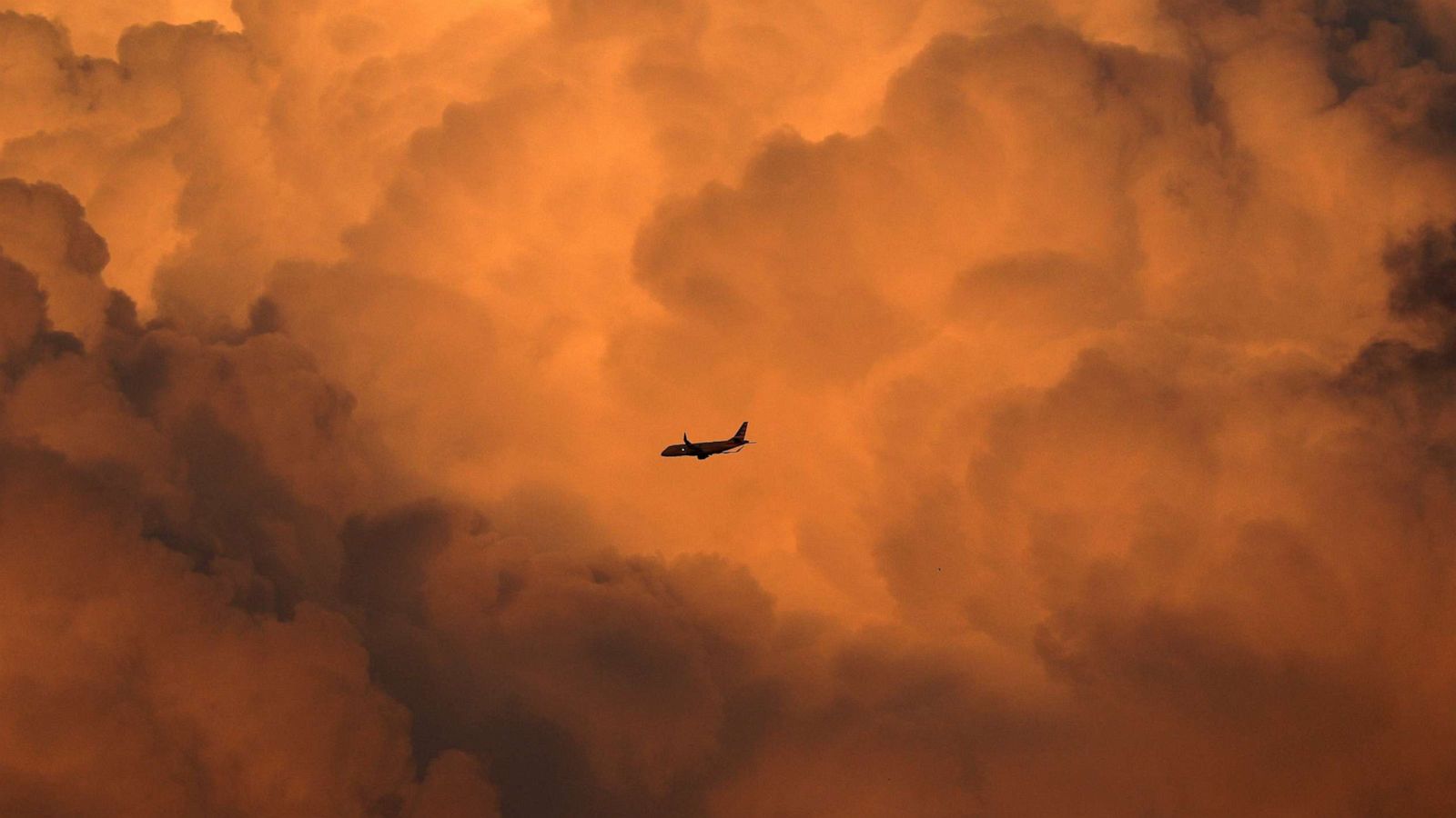 PHOTO: An airplane approaching LaGuardia Airport flies over New York City at sunset, Aug. 27, 2023.