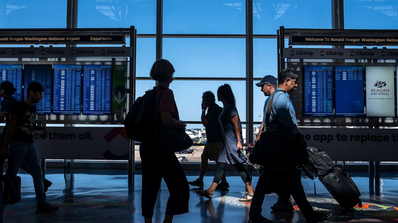 PHOTO: Travelers check their flight status at Ronald Regan Washington National Airport, July 11, 2022, in Arlington, Va.