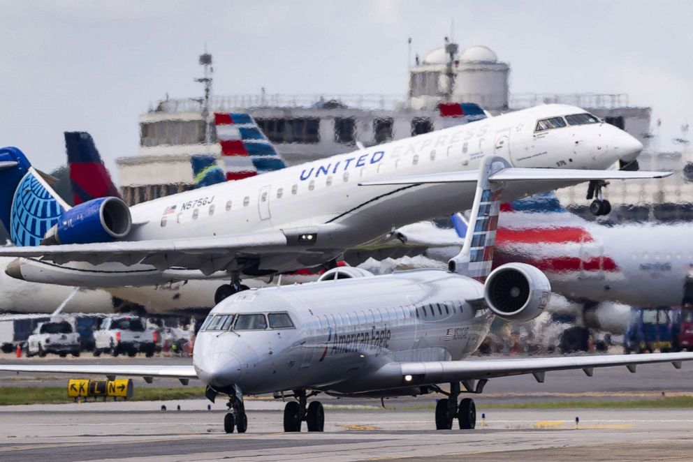 PHOTO: A United Express flight departs next to a taxiing American Eagle aircraft at Ronald Reagan Washington National Airport in Arlington, Virginia, on August 1, 2022. 