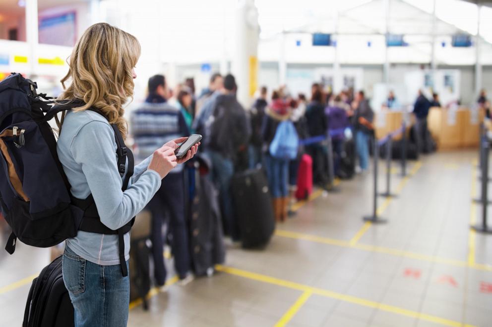 PHOTO: Stock photo of people in a queue to check in at an airport.