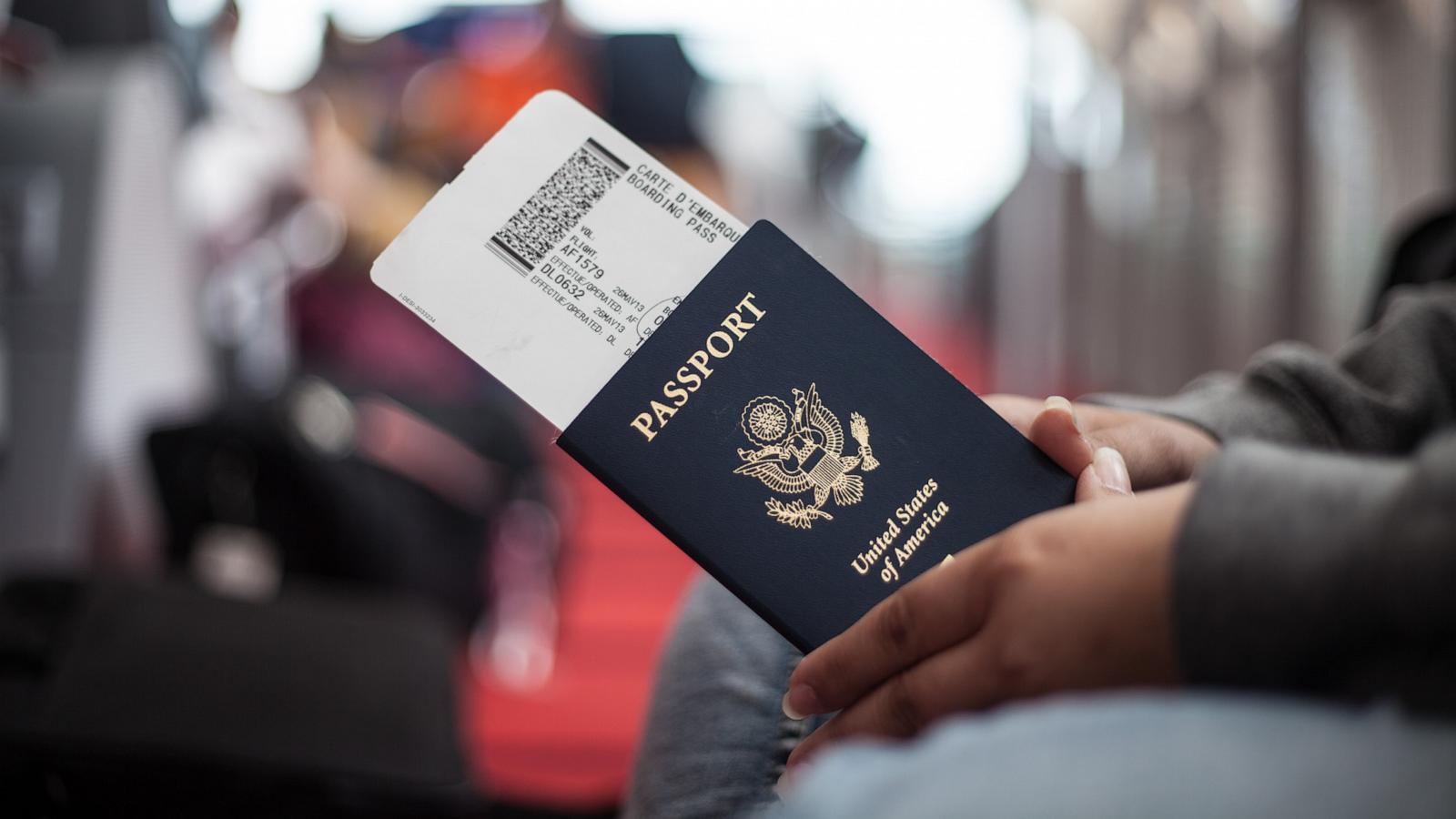 PHOTO: Close Up of a person holding an American Passport at an airport.