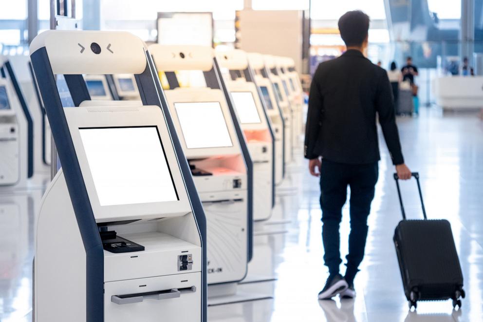 PHOTO: A man walks past a self service machine and help desk kiosk at airport terminal for check in this undated stock photo.