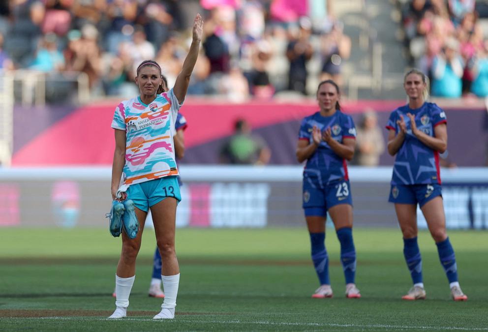 PHOTO: San Diego Wave FC forward Alex Morgan holds her cleats as she waves to fans after being subbed out in the final match of her career, Sept. 8, 2024, in San Diego