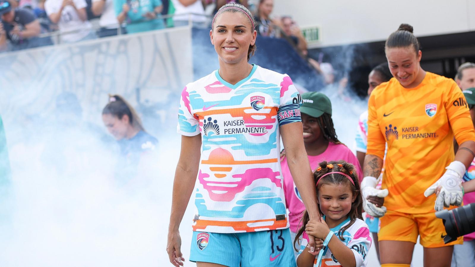 PHOTO: Alex Morgan of San Diego Wave FC walks onto the pitch with her daughter, Charlie before playing the last match of her career Sept. 8, 2024, in San Diego.