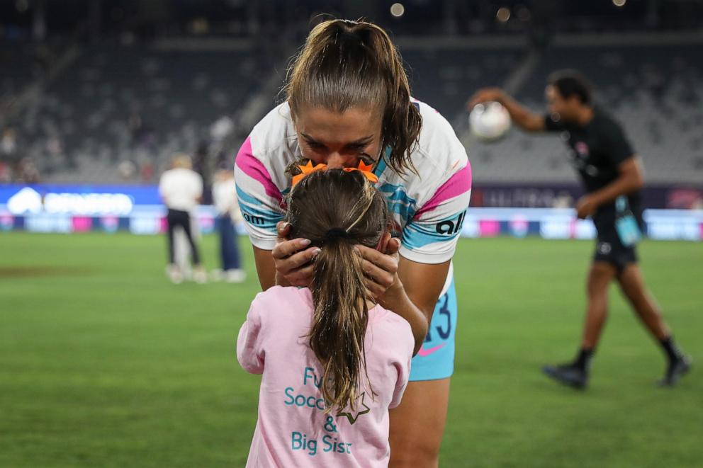 PHOTO: Alex Morgan of San Diego Wave FC kisses her daughter, Charlie, after the last match of her career Sept. 8, 2024, in San Diego.