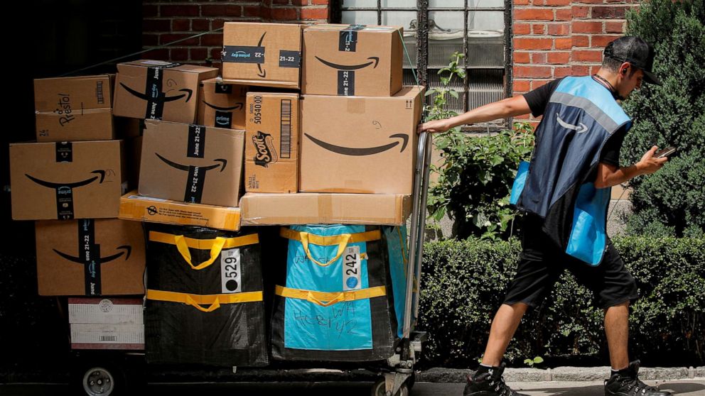 An Amazon delivery worker pulls a delivery cart full of packages during its annual Prime Day promotion in New York, June 21, 2021.
