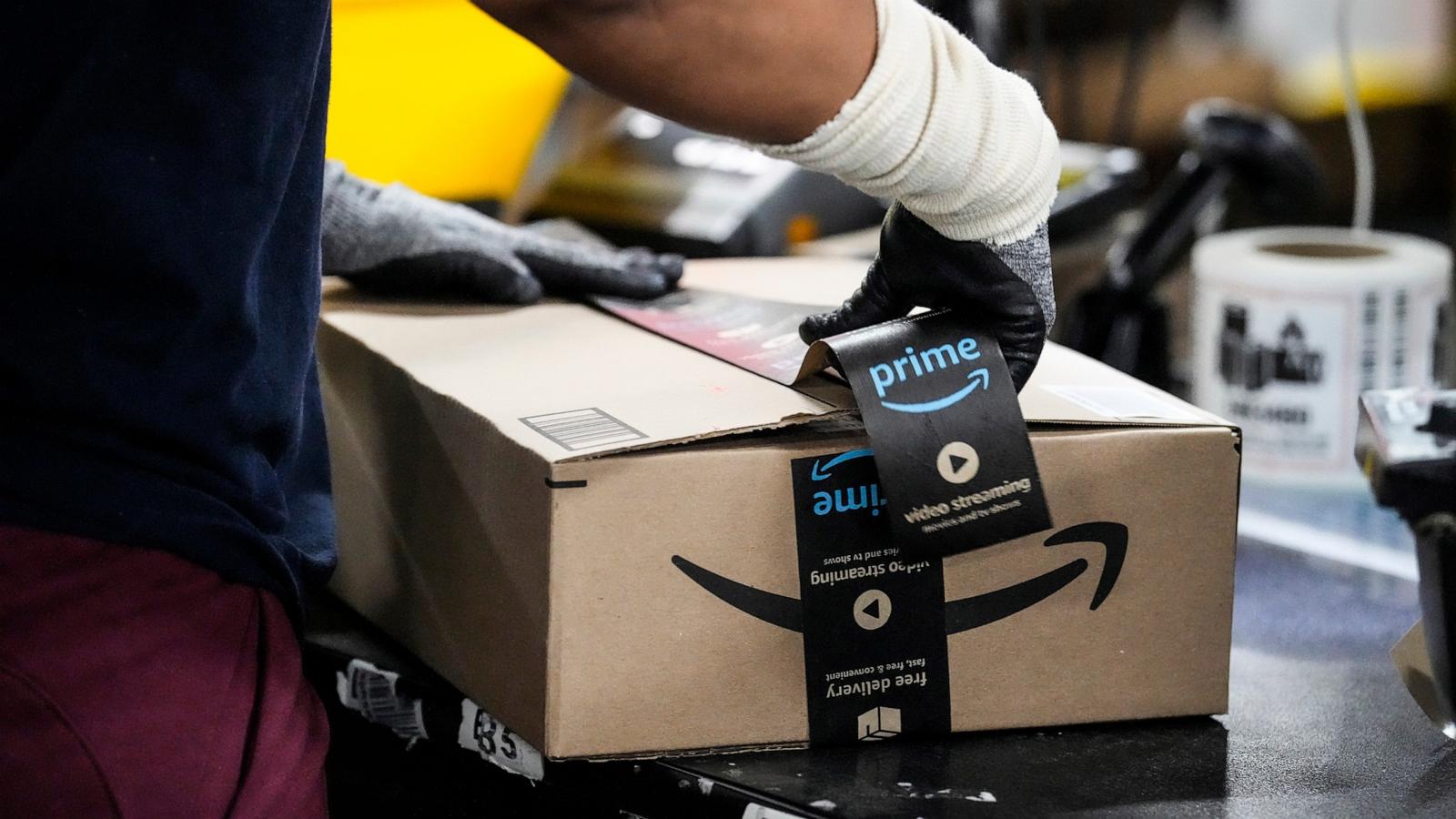 A wrker tapes up a box preparing an item to be shipped at the Amazon HOU6 Fulfillment Center, Nov. 27, 2023, in Richmond, Texas, 