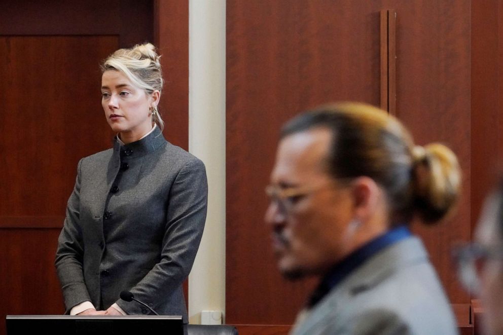 PHOTO: Actors Amber Heard and Johnny Depp watch as the jury leave the courtroom for a lunch break at the Fairfax County Circuit Courthouse in Fairfax, Va., May 16, 2022.