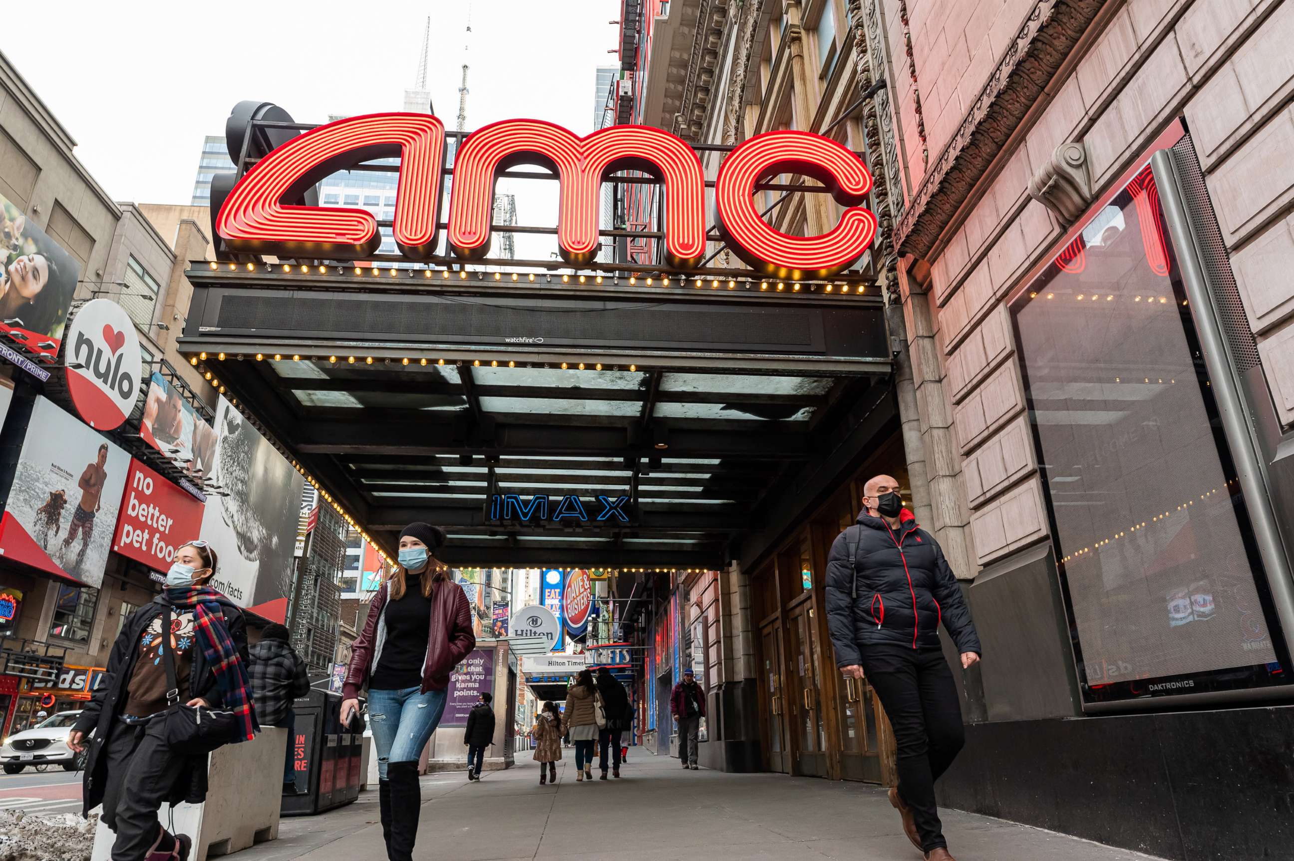 PHOTO: People walk outside the AMC Empire 25 movie theater in Times Square as the city continues the re-opening efforts following restrictions imposed to slow the spread of coronavirus, Dec. 23, 2020, New York.