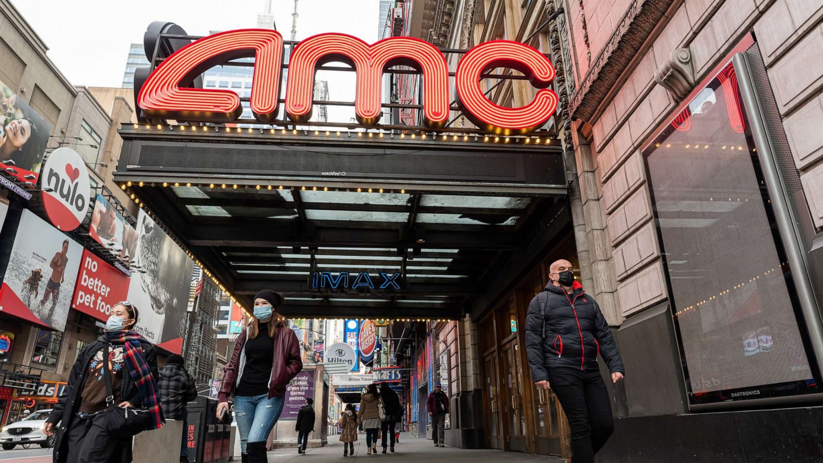 PHOTO: People walk outside the AMC Empire 25 movie theater in Times Square as the city continues the re-opening efforts following restrictions imposed to slow the spread of coronavirus, Dec. 23, 2020, New York.