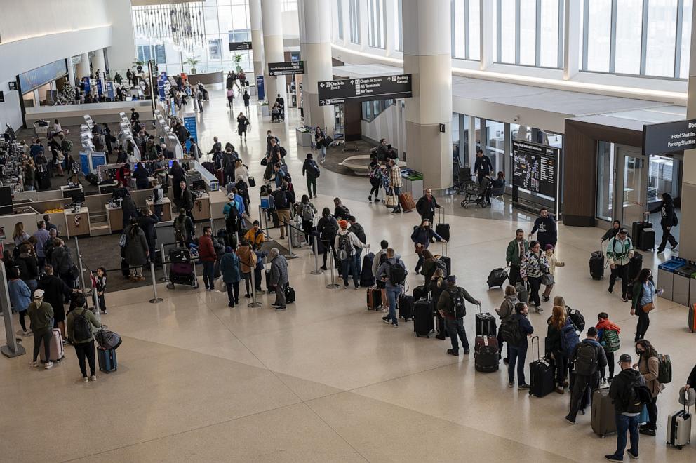 PHOTO: In this Dec. 21, 2023, file photo, travelers wait to check in at the American Airlines ticket counter at San Francisco International Airport (SFO) in San Francisco.