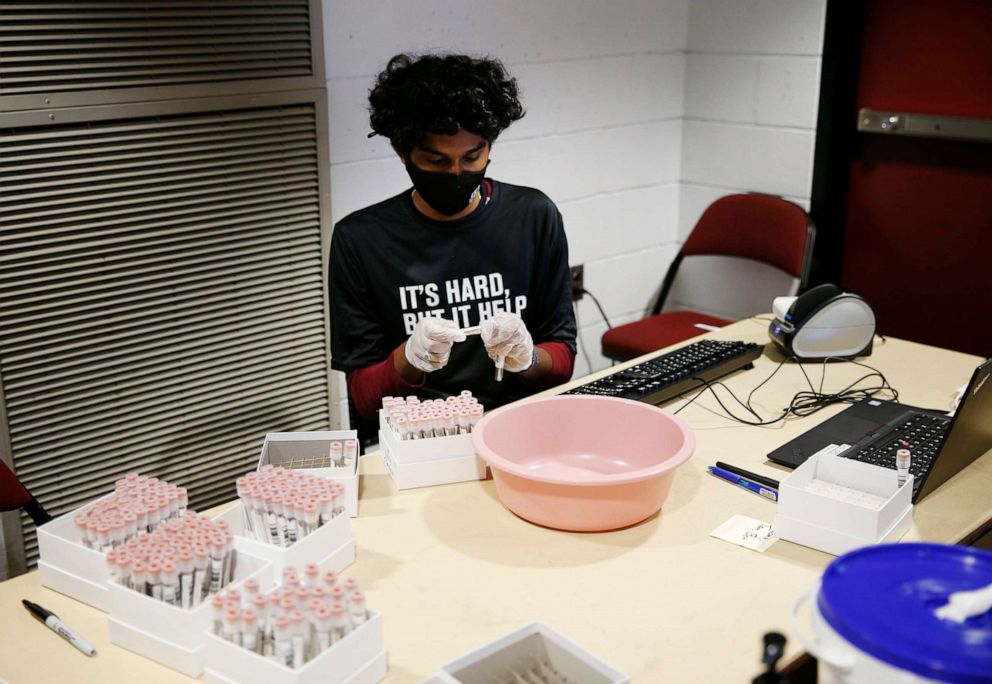 PHOTO: A specimen auditor inspects labels on COVID-19 samples to make sure they are affixed properly at UMass Amherst in Amherst, MA., on Sept. 9, 2020.