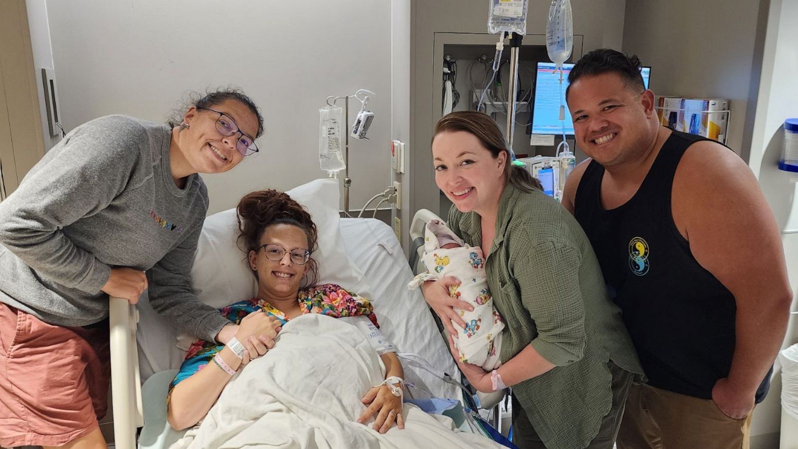 PHOTO: From left to right, Neva and Kelsey Benton smile for a photo with baby Ezri. Kelsey Benton, second from left, donated one of her eggs and became a surrogate for the Cardenas (right).