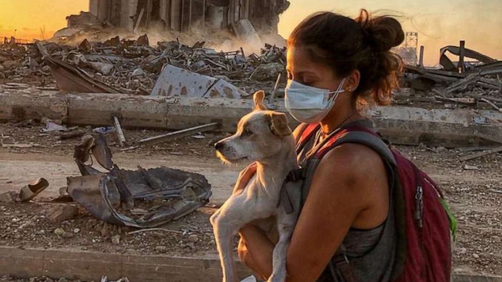 PHOTO: Animals Lebanon rescue team member holds a stray dog as she walks through what remains of Beirut after the Aug. 4, 2020 explosion.