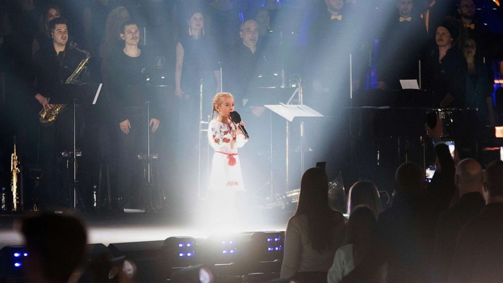 PHOTO: Seven-year-old Amellia Anisovych, a refugee from Ukraine, sings the Ukraine national anthem at the start of a fund-raising concert in Lodz, Poland, March 20, 2022.