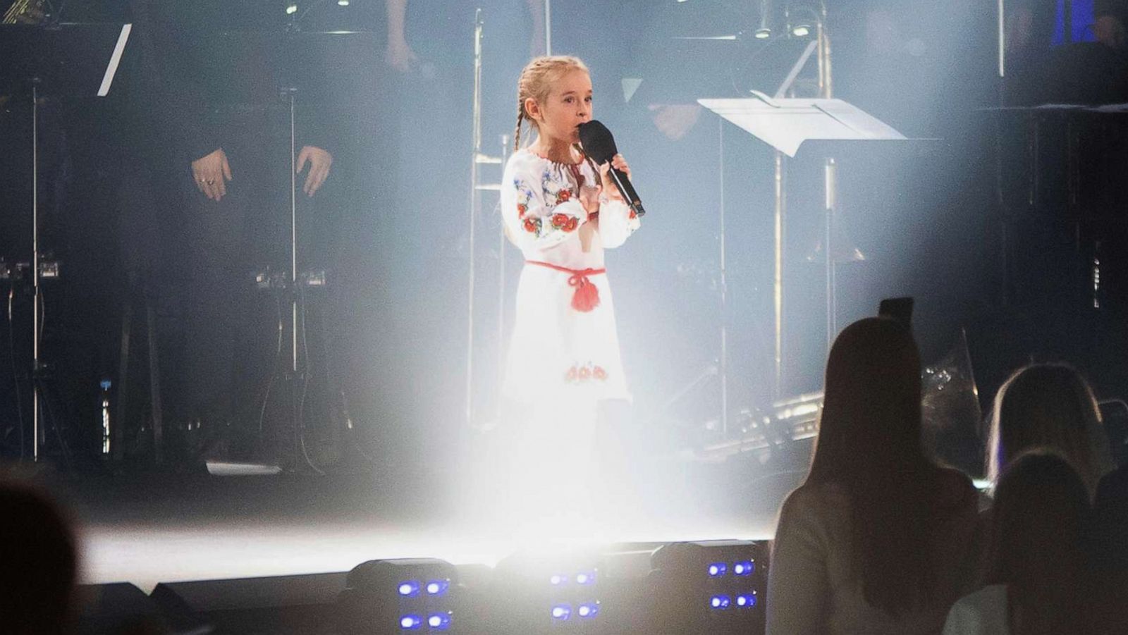 PHOTO: Seven-year-old Amellia Anisovych, a refugee from Ukraine, sings the Ukraine national anthem at the start of a fund-raising concert in Lodz, Poland, March 20, 2022.