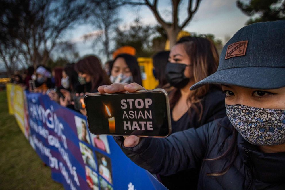 PHOTO: Julie Tran holds her phone during a candlelight vigil in Garden Grove, Calif., March 17, 2021, in response to the Atlanta shootings on March 16 and other instances of violence across the country targeting people of Asian descent.