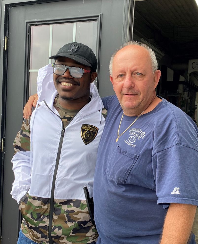 PHOTO: John Thomas Archer poses in a recent photo with Mark Waters, owner of ReMARKable Cleanouts in Norwood, permission. Waters gave Archer a piano after seeing a recorded video of Archer playing and wowing the shop.