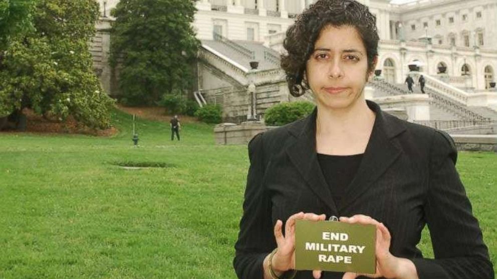 PHOTO: Anuradha Bhagwati with a card reading, "End Military Rape."