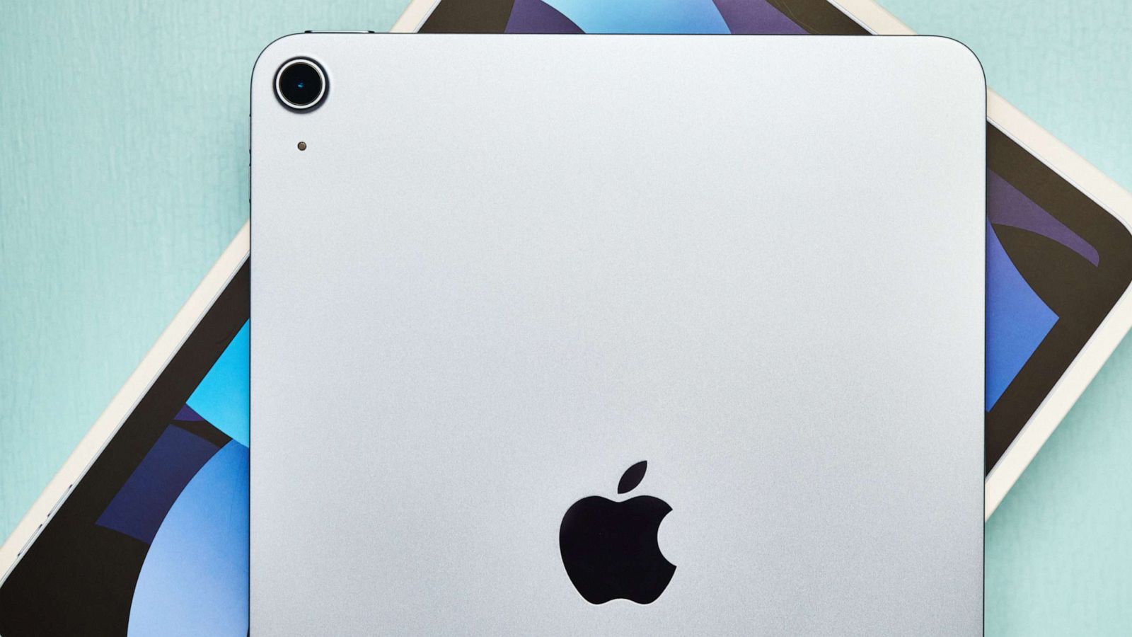 PHOTO: A studio shot of a brand new Apple iPad Air 4 in sky blue with its packaging on a pale blue surface.