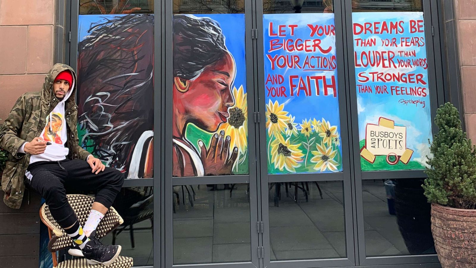 PHOTO: Artist Shawn Perkins is seen by his artwork at the Busboys and Poets K Street location in Washington, D.C.