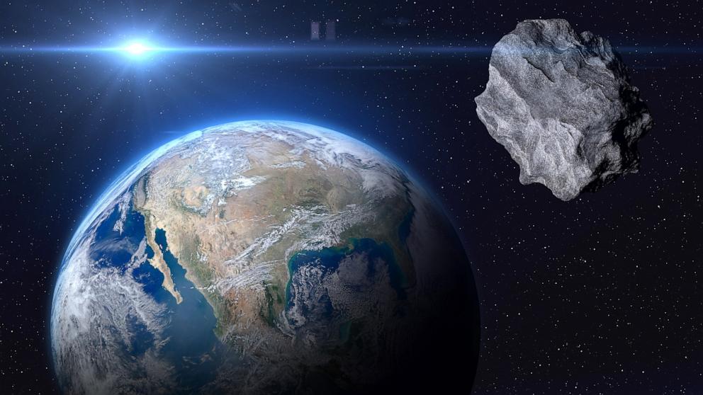 PHOTO: planet Earth and a big asteroid in space.