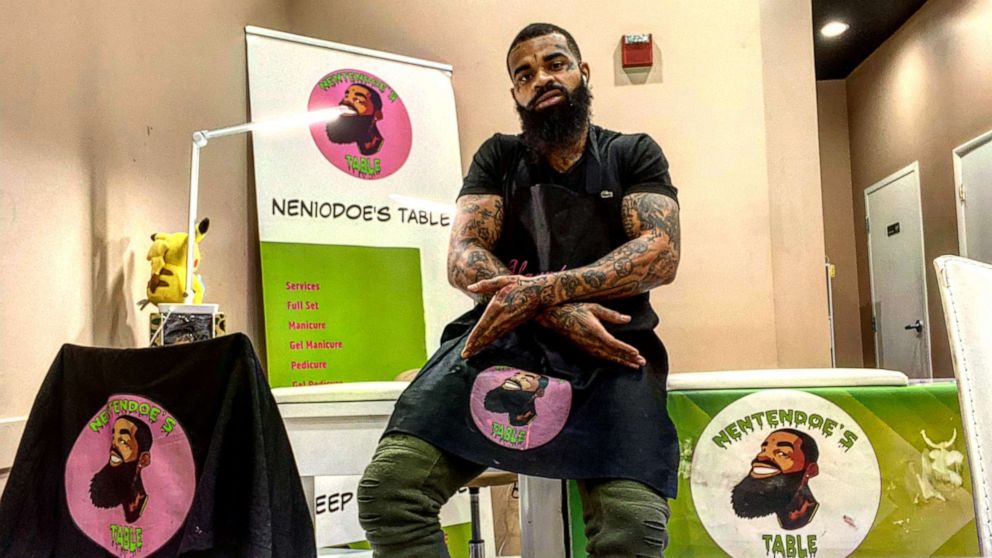 PHOTO: Atkins poses in front of his manicure table and T-shirts showcasing his business "Nentendoe's Table."