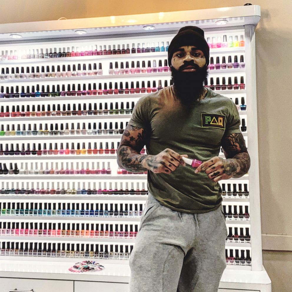 PHOTO: Atkins poses in front of a wall of nail polish at his former salon.