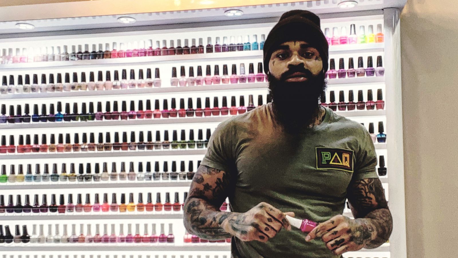 PHOTO: Atkins poses in front of a wall of nail polish at his former salon.