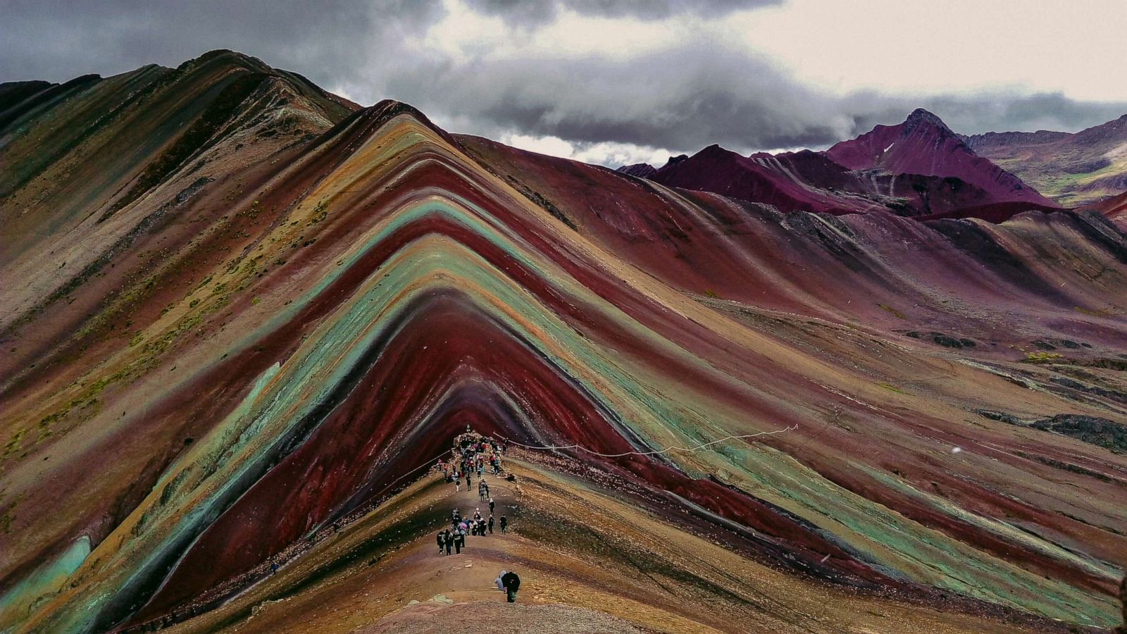 PHOTO: Visitors walk along the Rainbow Mountain on the Ausangate Trek in Pampamarca, Peru.